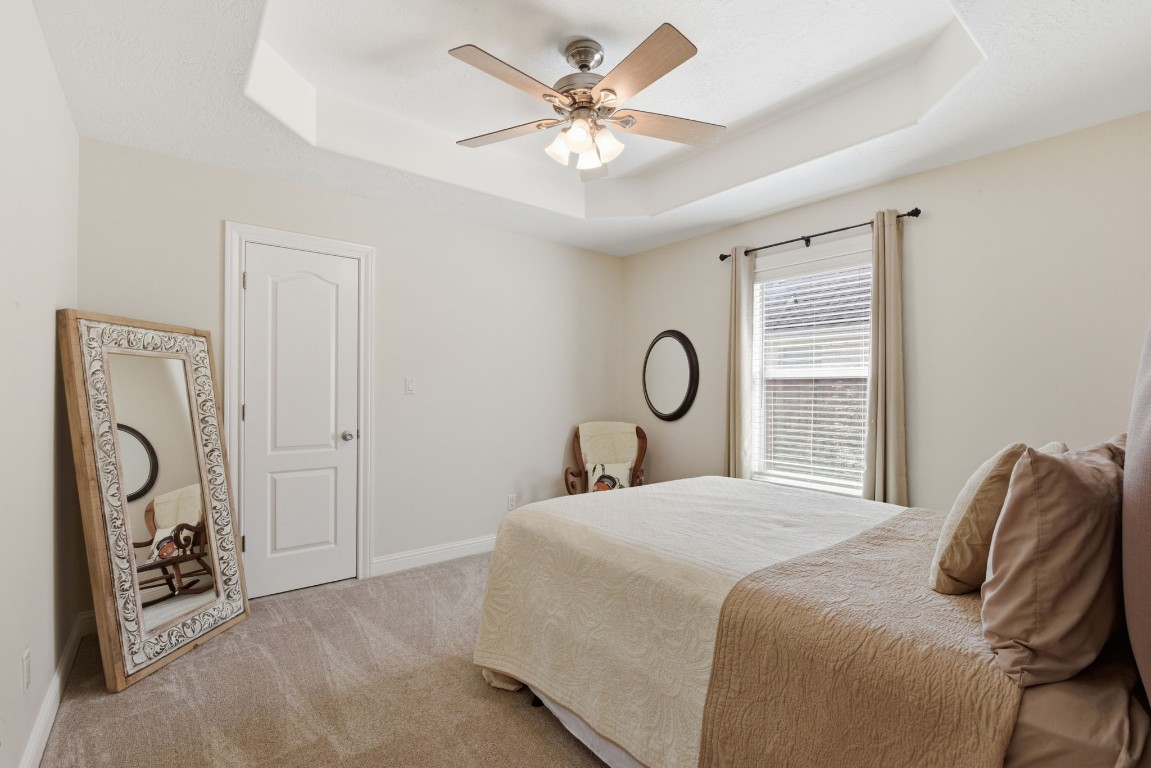 232 North Dixie Street Brenham, TX 77833 - Photo 31 of 41 This cozy bedroom features neutral tones with a tray ceiling. It includes a large window for natural light.