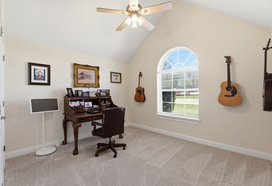 232 North Dixie Street Brenham, TX 77833 - Photo 34 of 41 This room features a cozy office space with a vaulted ceiling, a large arched window for natural light, and neutral carpeting.