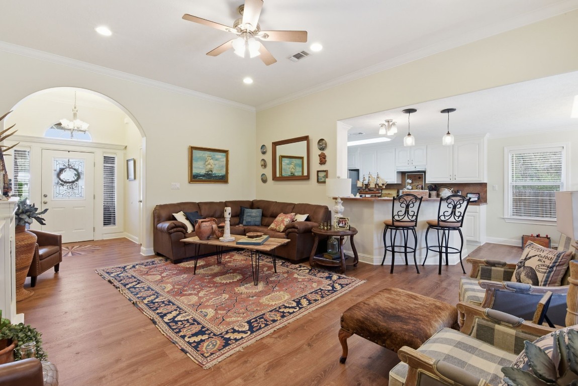 232 North Dixie Street Brenham, TX 77833 - Photo 8 of 41 This inviting living area features an open layout with warm wood floors. The space flows seamlessly into a bright kitchen with a breakfast bar and elegant pendant lighting, creating a perfect setting for entertaining.
