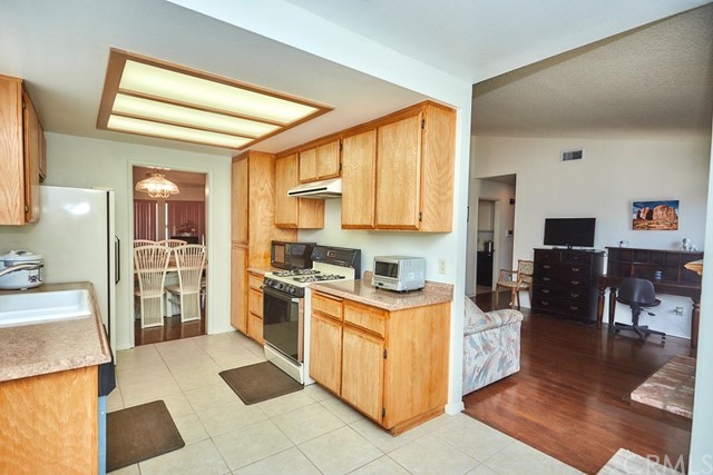 471 Silverado Street Barstow, CA 92311 - Photo 14 of 43 a kitchen with stainless steel appliances granite countertop a stove top oven a sink a dining table and chairs with wooden floor
