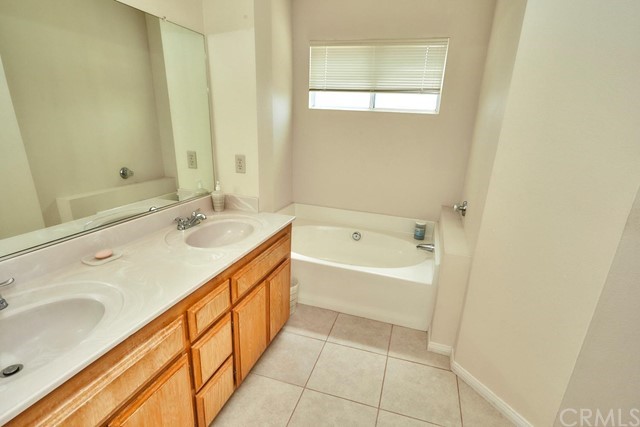 471 Silverado Street Barstow, CA 92311 - Photo 31 of 43 a spacious bathroom with a bathtub sink and mirror