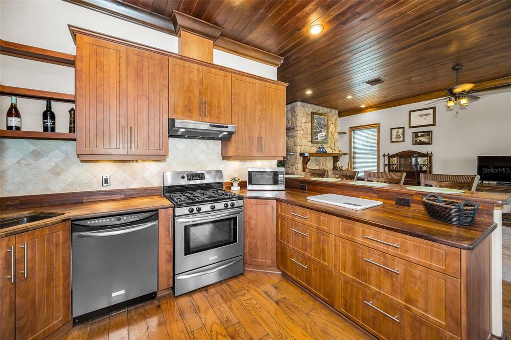 6141 Lafayette Street New Port Richey, FL 34652 - Photo 17 of 98 a kitchen with stainless steel appliances granite countertop a stove a sink and a microwave