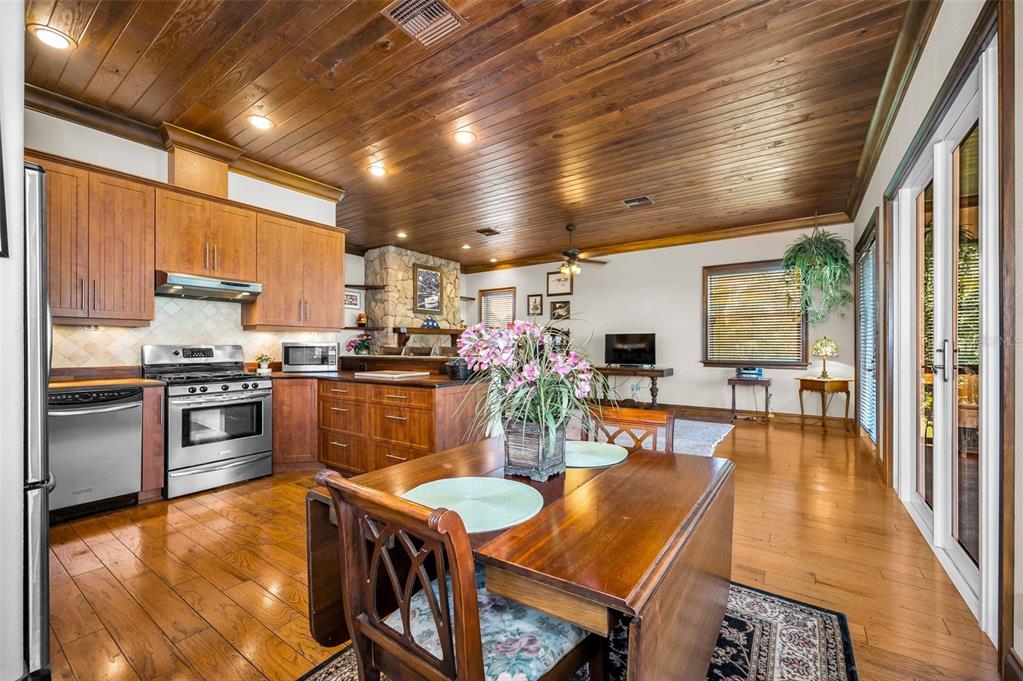 6141 Lafayette Street New Port Richey, FL 34652 - Photo 22 of 98 a kitchen with stainless steel appliances granite countertop a stove refrigerator dining table and chairs