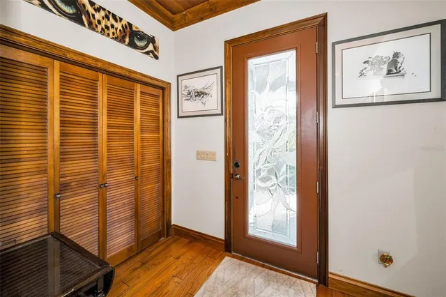 a kitchen with stainless steel appliances granite countertop a refrigerator a sink dishwasher a dining table and chairs with wooden floor