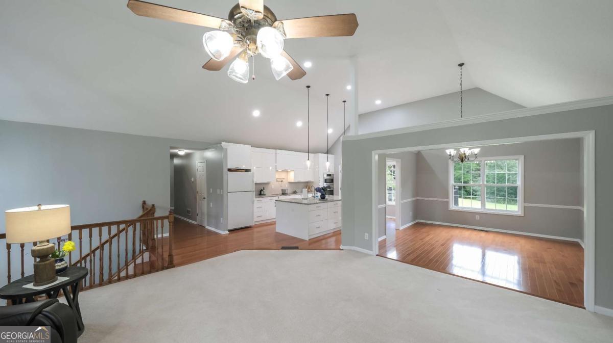 a open kitchen with stainless steel appliances granite countertop a refrigerator a stove a sink dishwasher and a dining table with the view of kitchen
