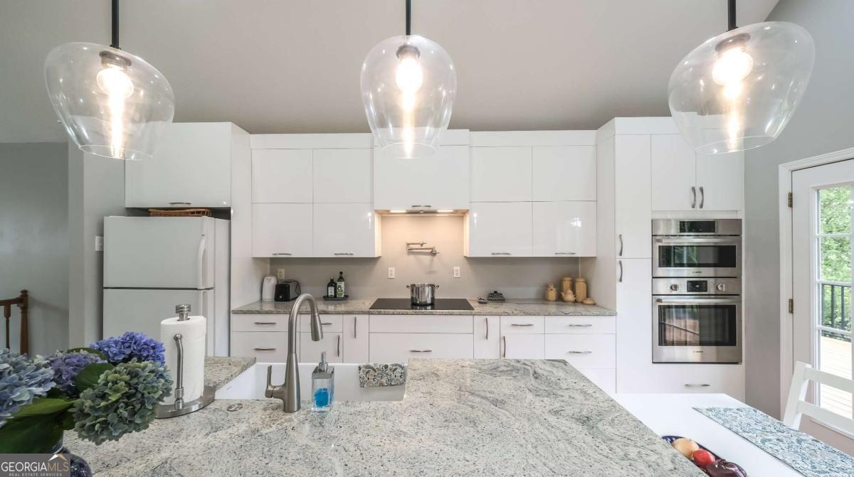 a kitchen with stainless steel appliances kitchen island granite countertop a sink a stove and cabinets