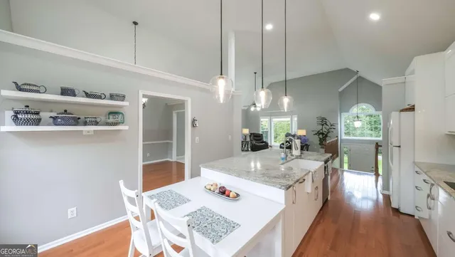 a view of a livingroom with a furniture wooden floor kitchen chandelier and a living room