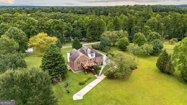 an aerial view of a house with swimming pool and a yard