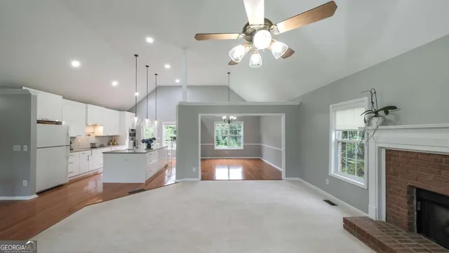 a open kitchen with stainless steel appliances granite countertop a refrigerator a stove a sink dishwasher and a dining table with the view of kitchen