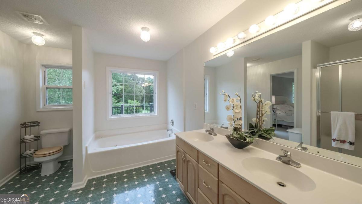 45 Buell Jones Road Carrollton, GA 30117 - Photo 27 of 60 a bathroom with a double vanity sink toilet and shower