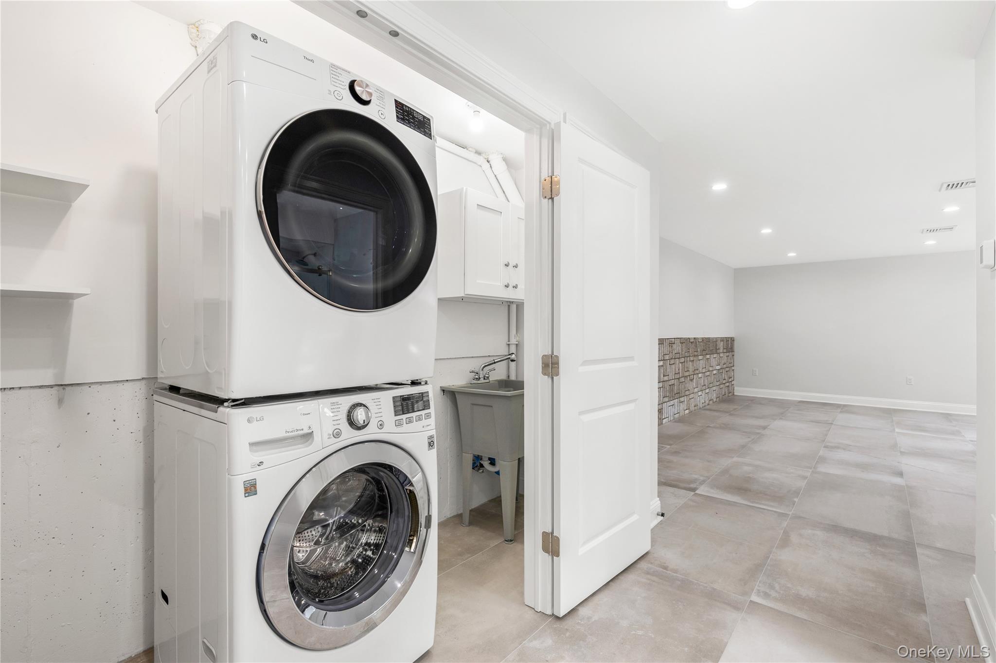 535 2nd Street, Unit DUPLEX R Mamaroneck, NY 10543 - Photo 25 of 32 The Lower Level Laundry closet neatly contains a washer/dryer, a sink and additional room for cleaning products and extra storage.