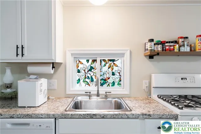 a kitchen with kitchen island a sink a stove and a window