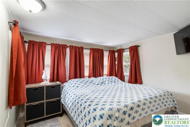 a large bed sitting in a bedroom next to a window