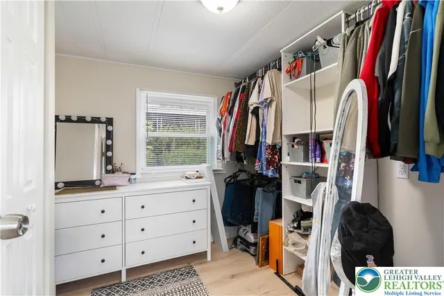 a view of walk in closet with clothes and shoes