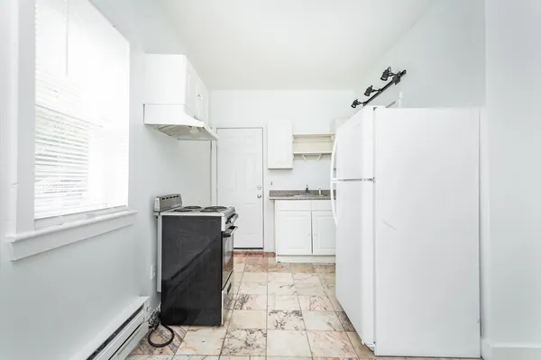 a kitchen with a refrigerator and a stove