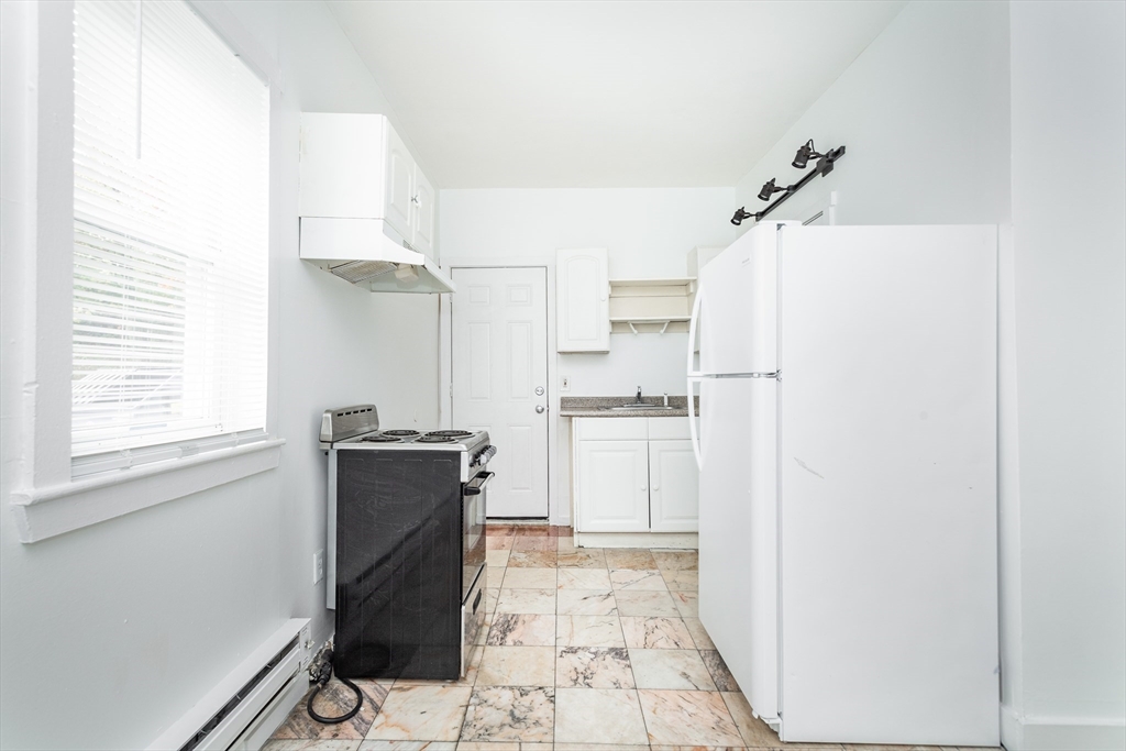 289 Hancock Street, Unit 1 Boston, MA 02125 - Photo 4 of 7 a kitchen with a refrigerator and a stove
