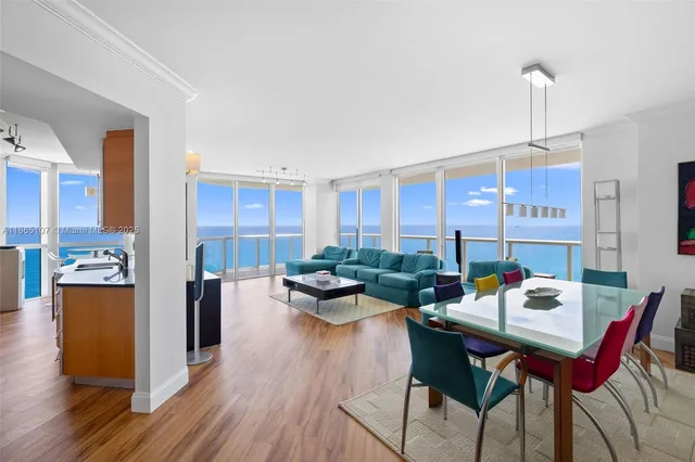 a living room with stainless steel appliances kitchen island a table and chairs in it