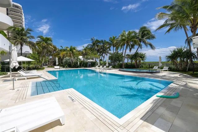 a front view of multi story residential apartment building with yard and parking space