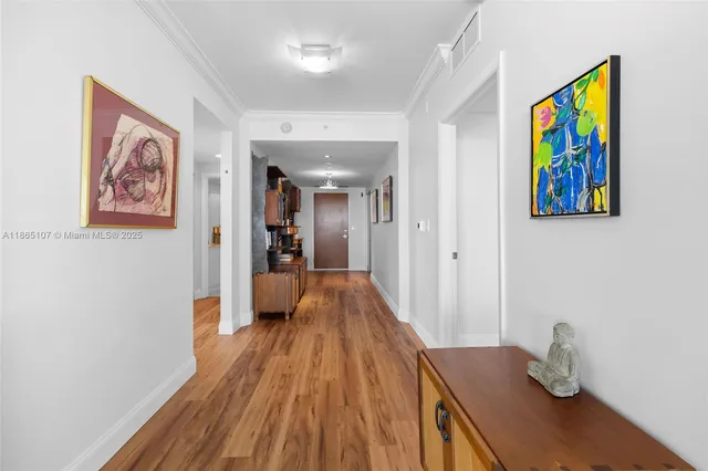 a view of a hallway with wooden floor and furniture