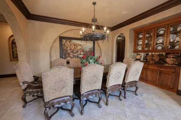 a view of a dining room with furniture a chandelier and large windows