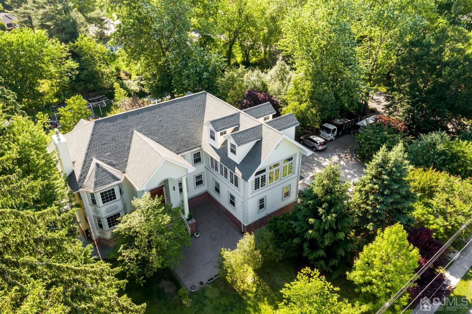 an aerial view of a house with a yard potted plants and large trees