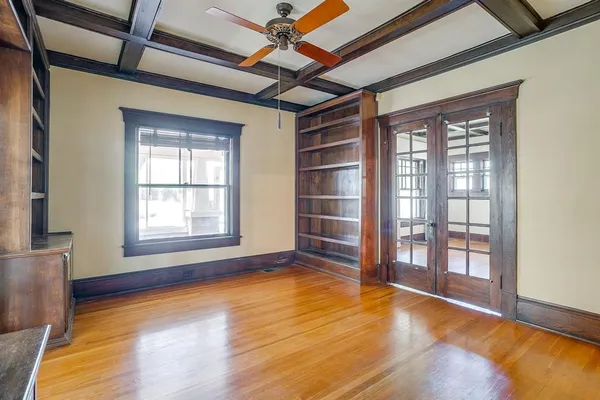 a view of an empty room with a window and wooden floor
