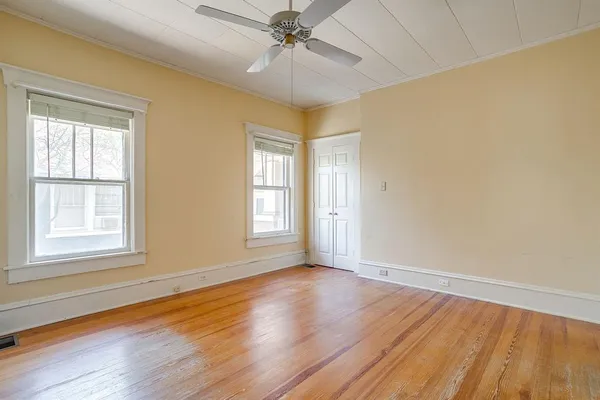 a view of a hallway with wooden floor and staircase