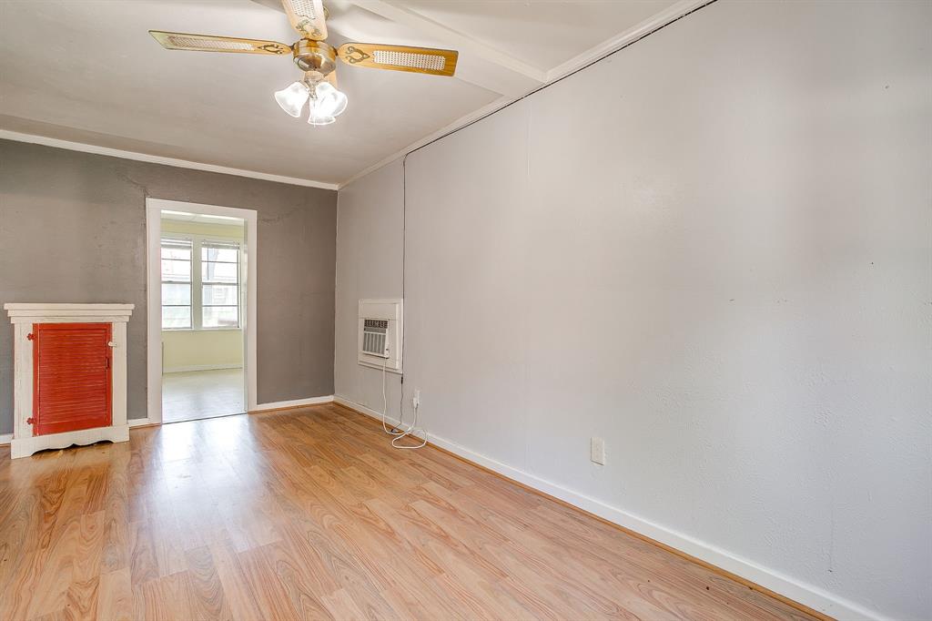 2124 Weatherbee Street Fort Worth, TX 76110 - Photo 33 of 39 an empty room with wooden floor chandelier fan and windows