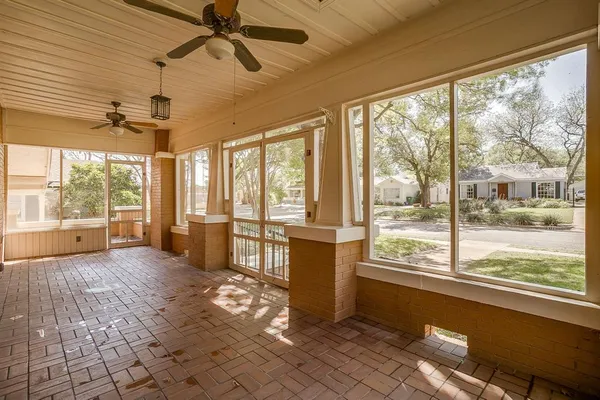a living room with hardwood floor and large windows