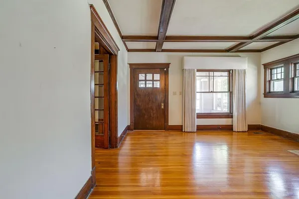 a view of a hallway with wooden floor and windows