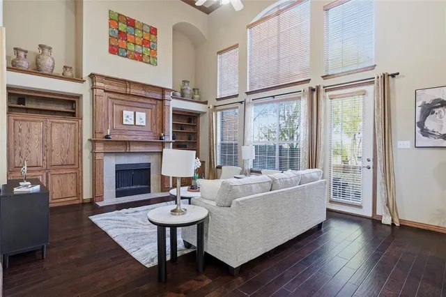 a living room with furniture large window and wooden floor