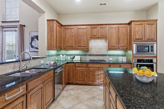 a kitchen with stainless steel appliances granite countertop a sink stove and cabinets