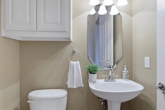 a bathroom with a sink a toilet and mirror
