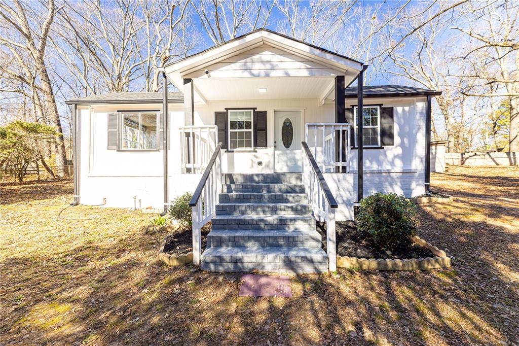 a view of a house with large windows and a small yard