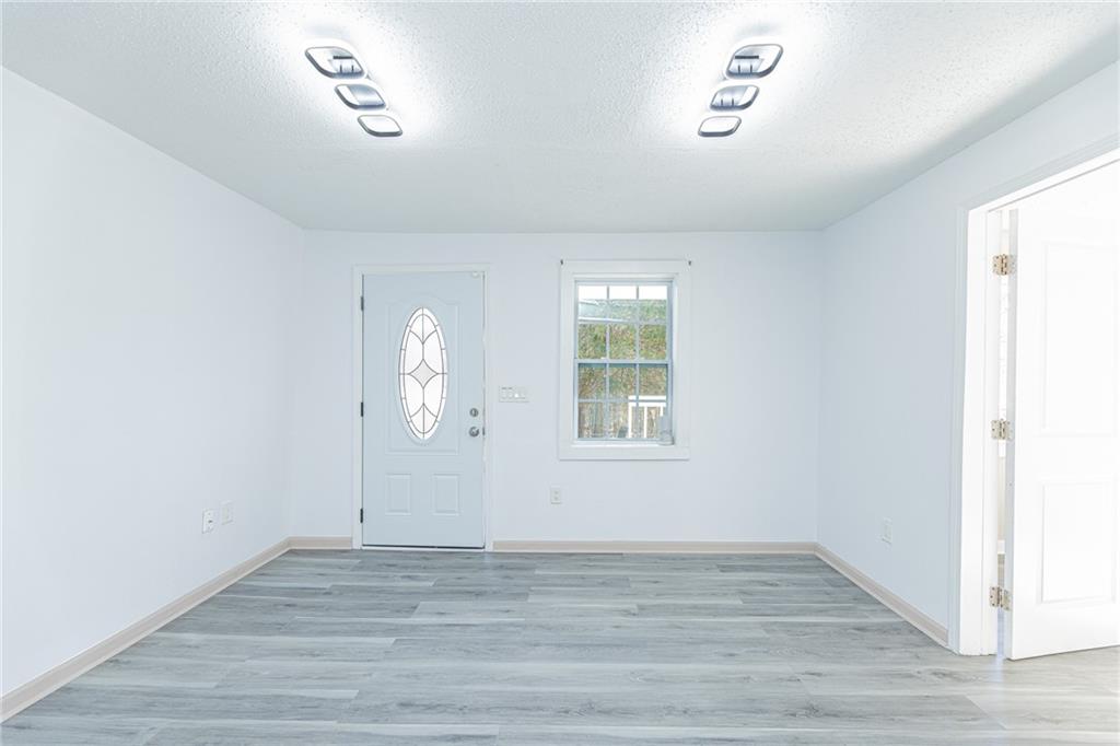 6197 Union Grove Road Lithia Springs, GA 30122 - Photo 11 of 24 an empty room with wooden floor cabinet and windows