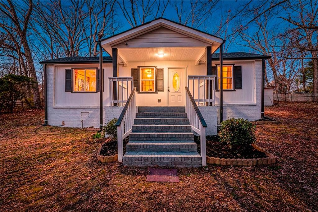6197 Union Grove Road Lithia Springs, GA 30122 - Photo 2 of 24 a view of a house with lots of plants and a large tree