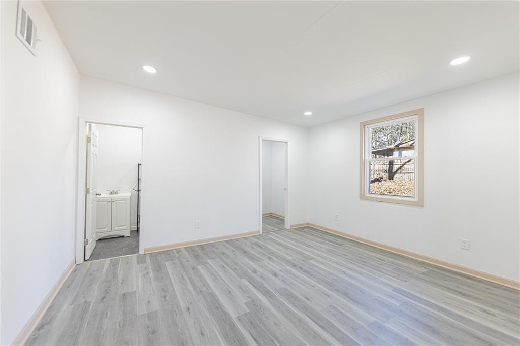 6197 Union Grove Road Lithia Springs, GA 30122 - Photo 5 of 24 an empty room with wooden floor and windows