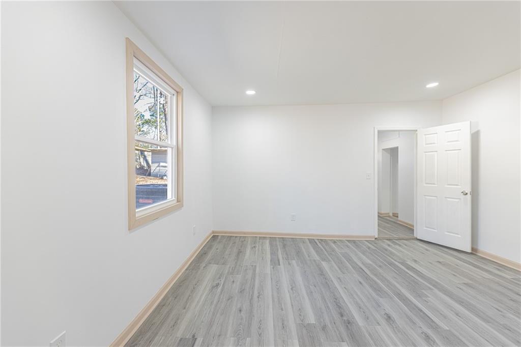 6197 Union Grove Road Lithia Springs, GA 30122 - Photo 9 of 24 an empty room with wooden floor and windows