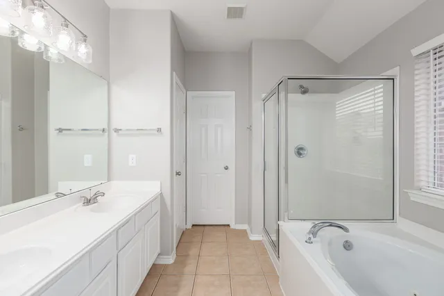 a spacious bathroom with a double vanity sink mirror and shower