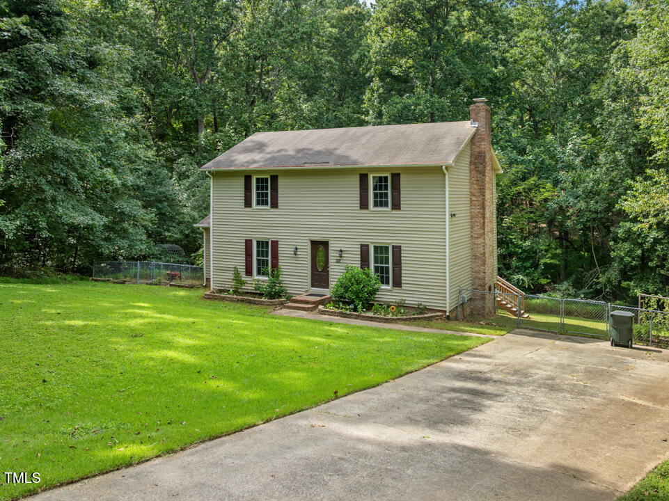 a aerial view of a house next to a big yard and large trees