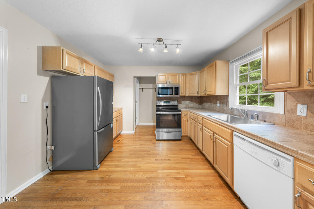 122 Stedwick Place Durham, NC 27712 - Photo 12 of 35 a large kitchen with a large window stainless steel appliances and cabinets