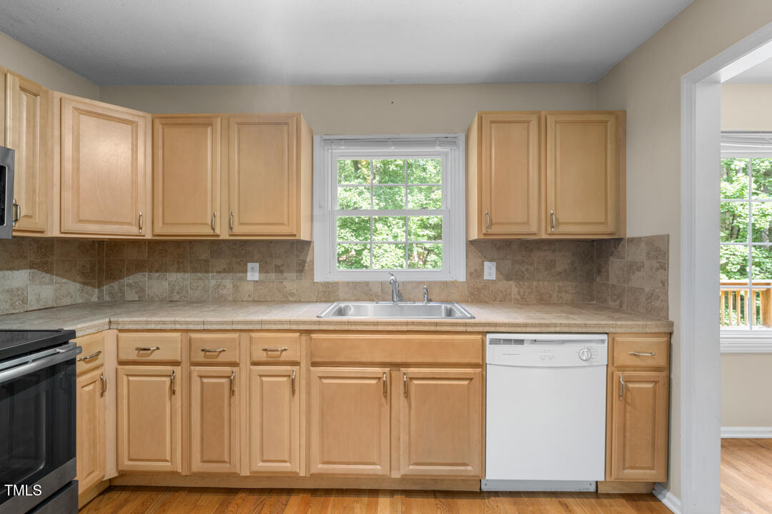 122 Stedwick Place Durham, NC 27712 - Photo 14 of 35 a kitchen with white cabinets white appliances and a sink
