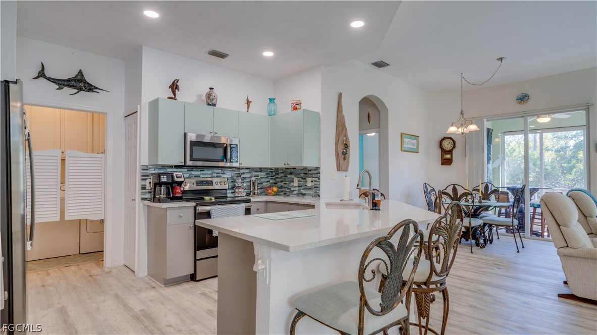 3181 Matecumbe Key Road, Unit 4 Punta Gorda, FL 33955 - Photo 13 of 50 a kitchen with stainless steel appliances a dining table chairs stove and refrigerator