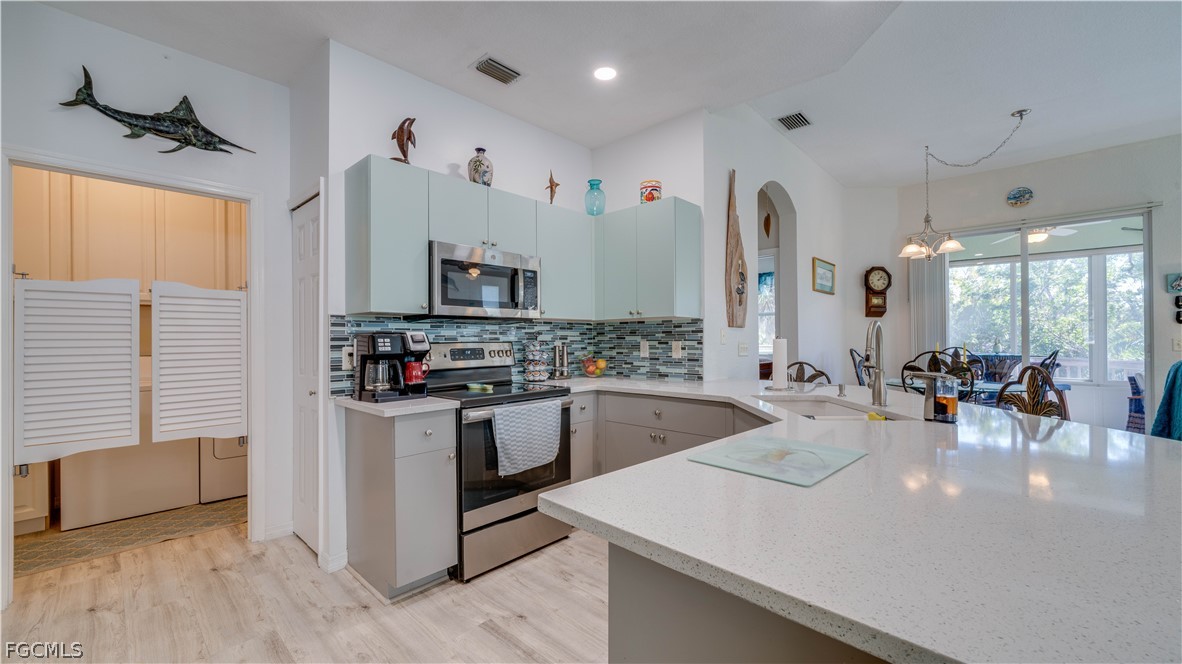 3181 Matecumbe Key Road, Unit 4 Punta Gorda, FL 33955 - Photo 14 of 50 a kitchen with stainless steel appliances granite countertop a sink stove and refrigerator