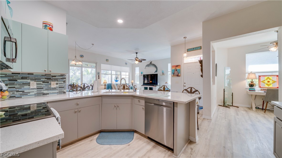 3181 Matecumbe Key Road, Unit 4 Punta Gorda, FL 33955 - Photo 15 of 50 a kitchen with white cabinets a sink dishwasher and a stove with wooden floor