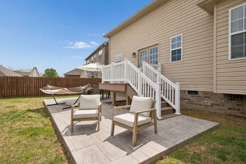 a view of a house with backyard and furniture
