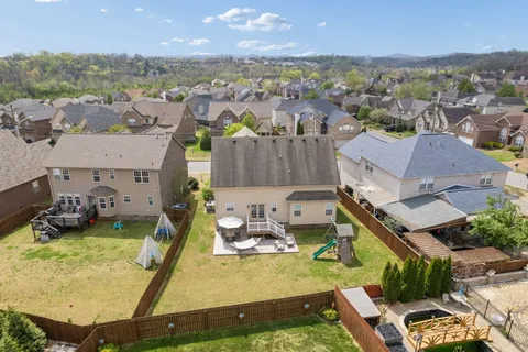 an aerial view of a house with yard swimming pool and mountain view in back