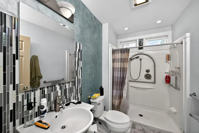 a bathroom with a sink a toilet and shower