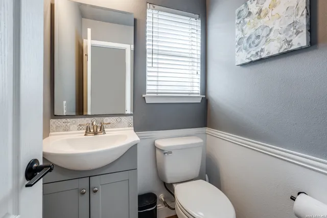a bathroom with a toilet sink and mirror