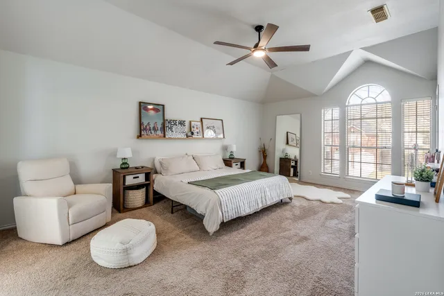 a spacious bedroom with a bed a couch and a large window